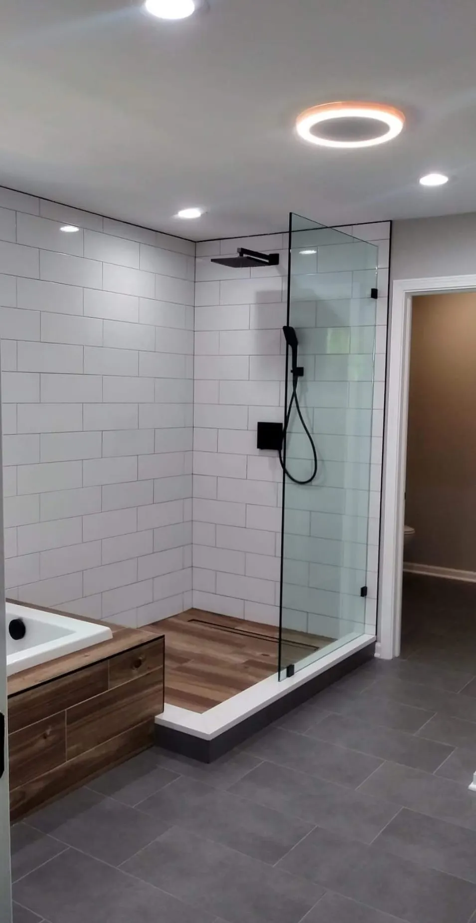 Bathroom remodel with large-format subway tile, glass-panel shower, and black fixtures in Bloomingdale