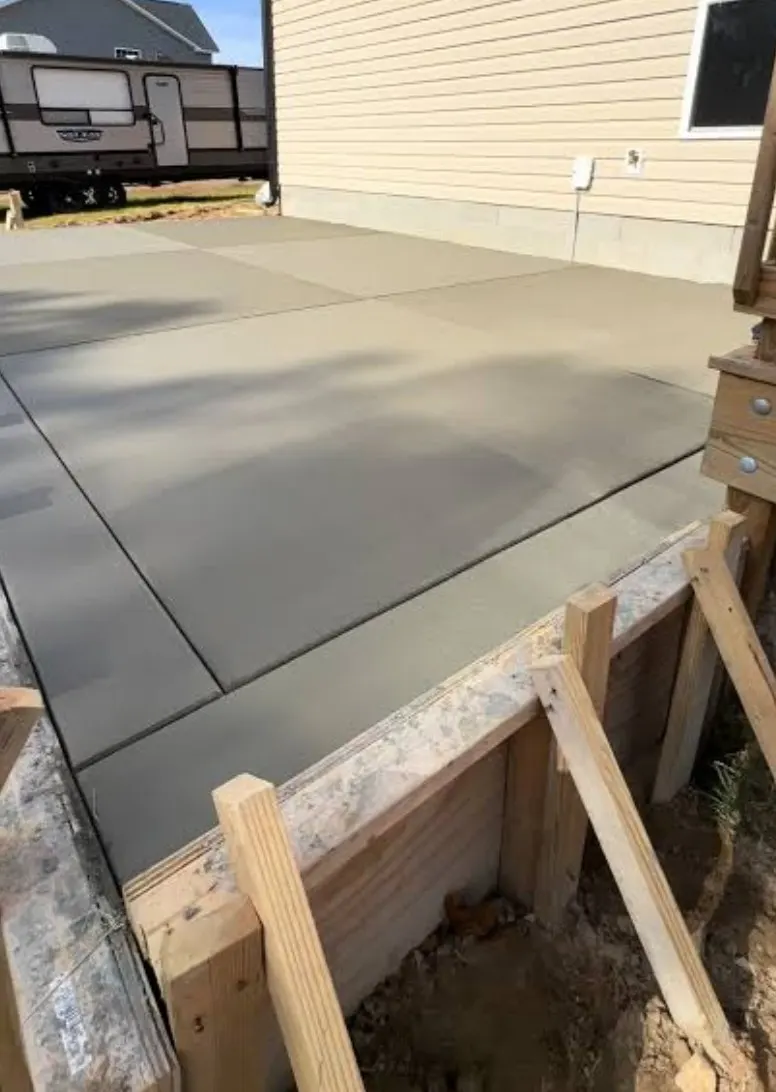 Freshly poured and finished concrete slab held by wood forms