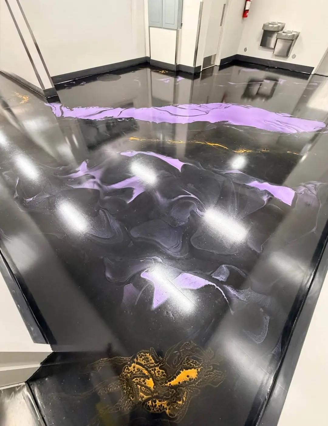 Glossy black epoxy floor with purple metallic swirls