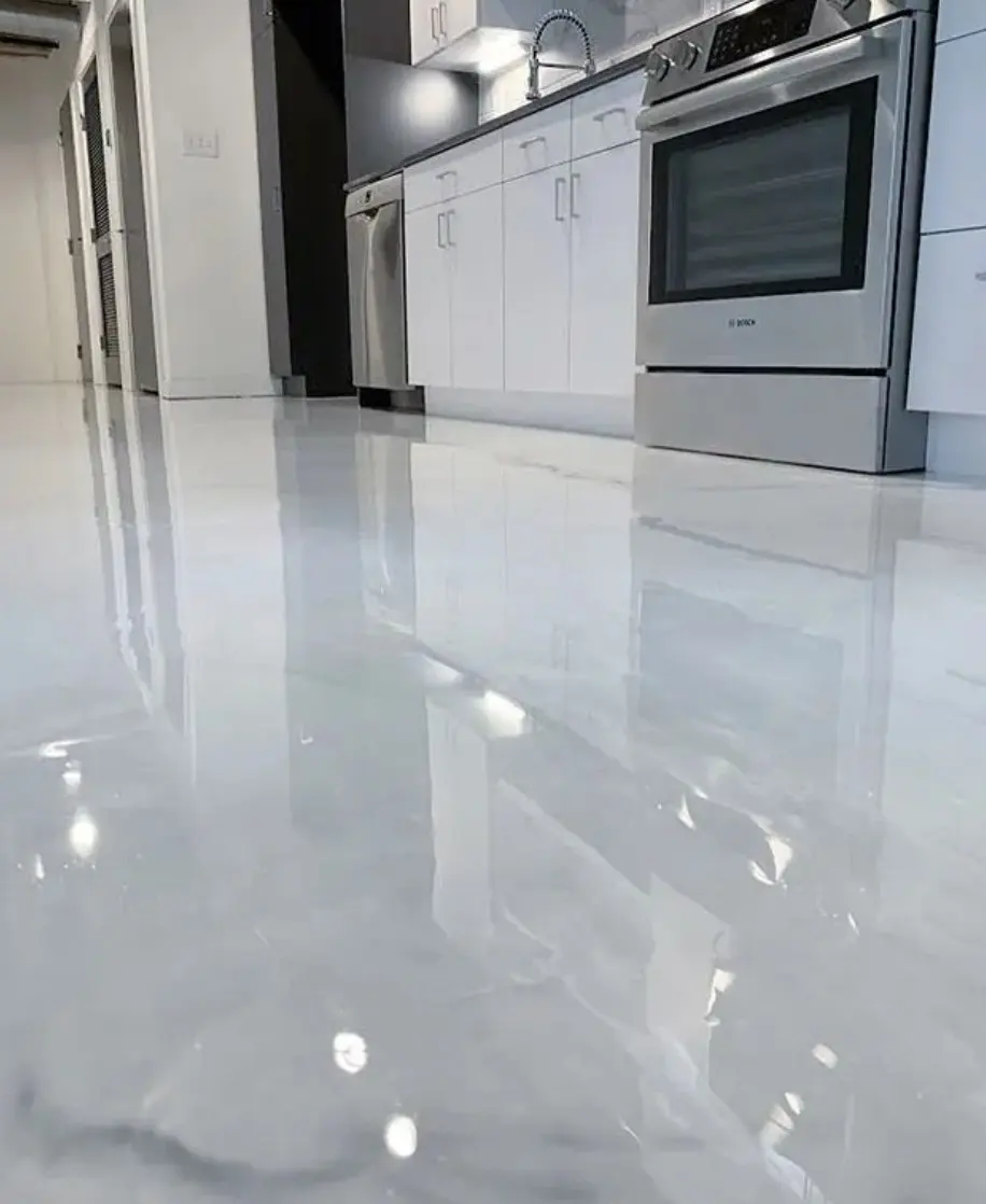 Glossy white marbled epoxy floor in a kitchen with white cabinets