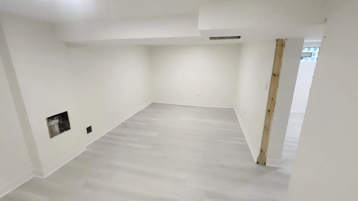 Basement room with new light gray plank flooring and white walls