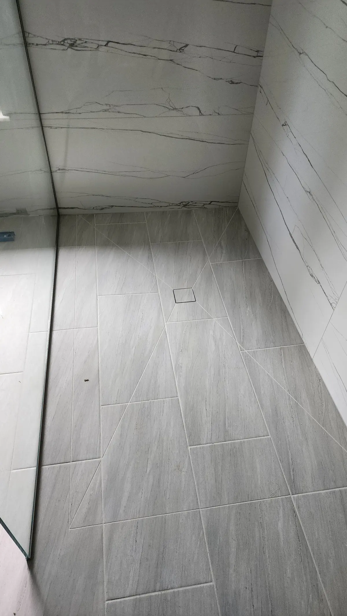 Gray plank tile floor and tiled wall in a new bathroom