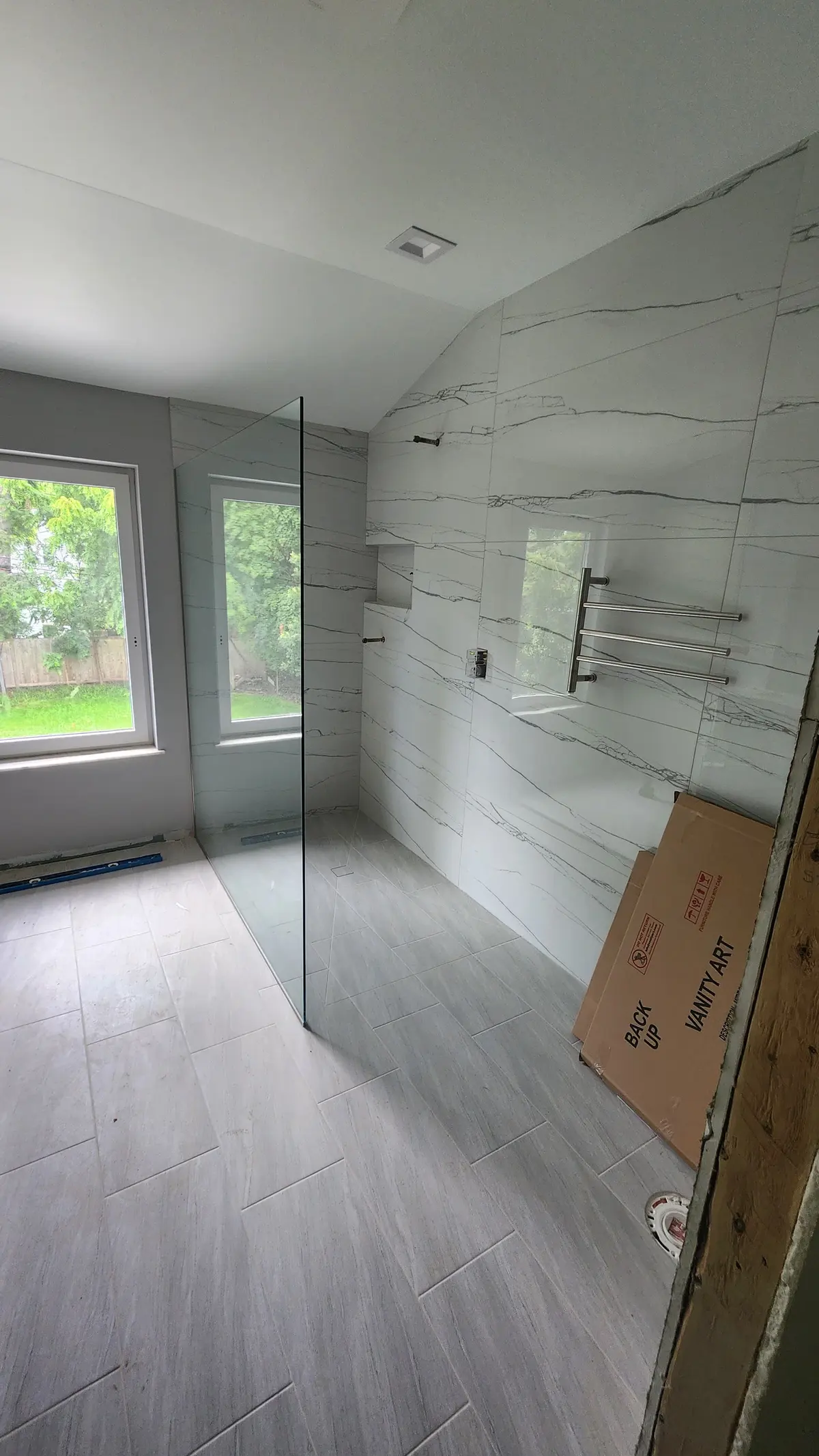 Bathroom with gray plank tile floor and a glass walk-in shower