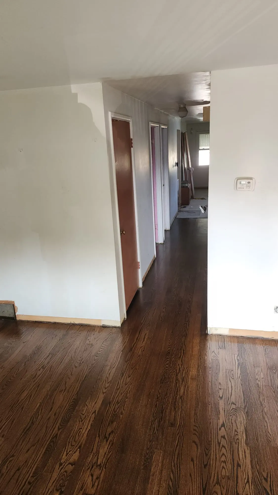 Sanded and refinished dark-stained hardwood floor running down a hallway in Bloomingdale