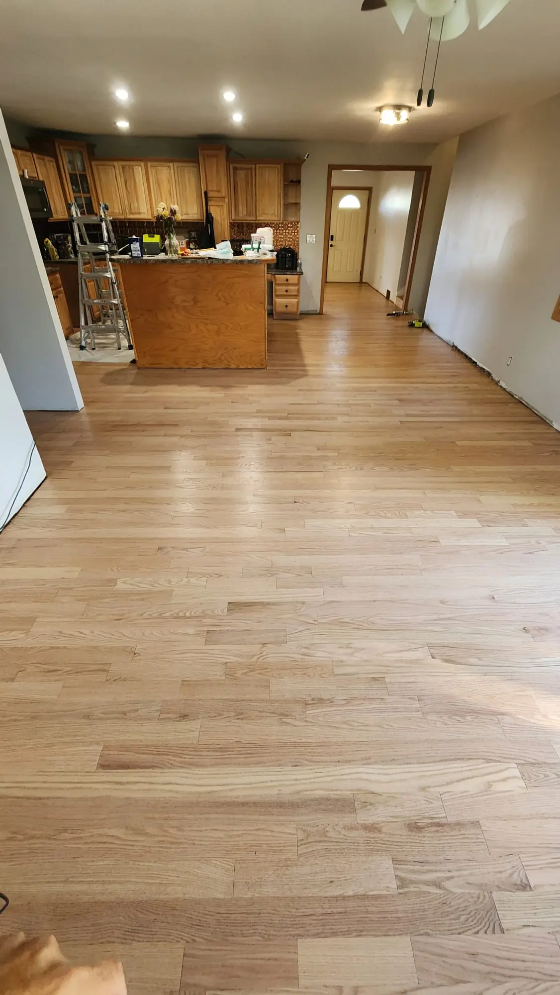 Refinished oak hardwood floor running from kitchen into living area in Bloomingdale