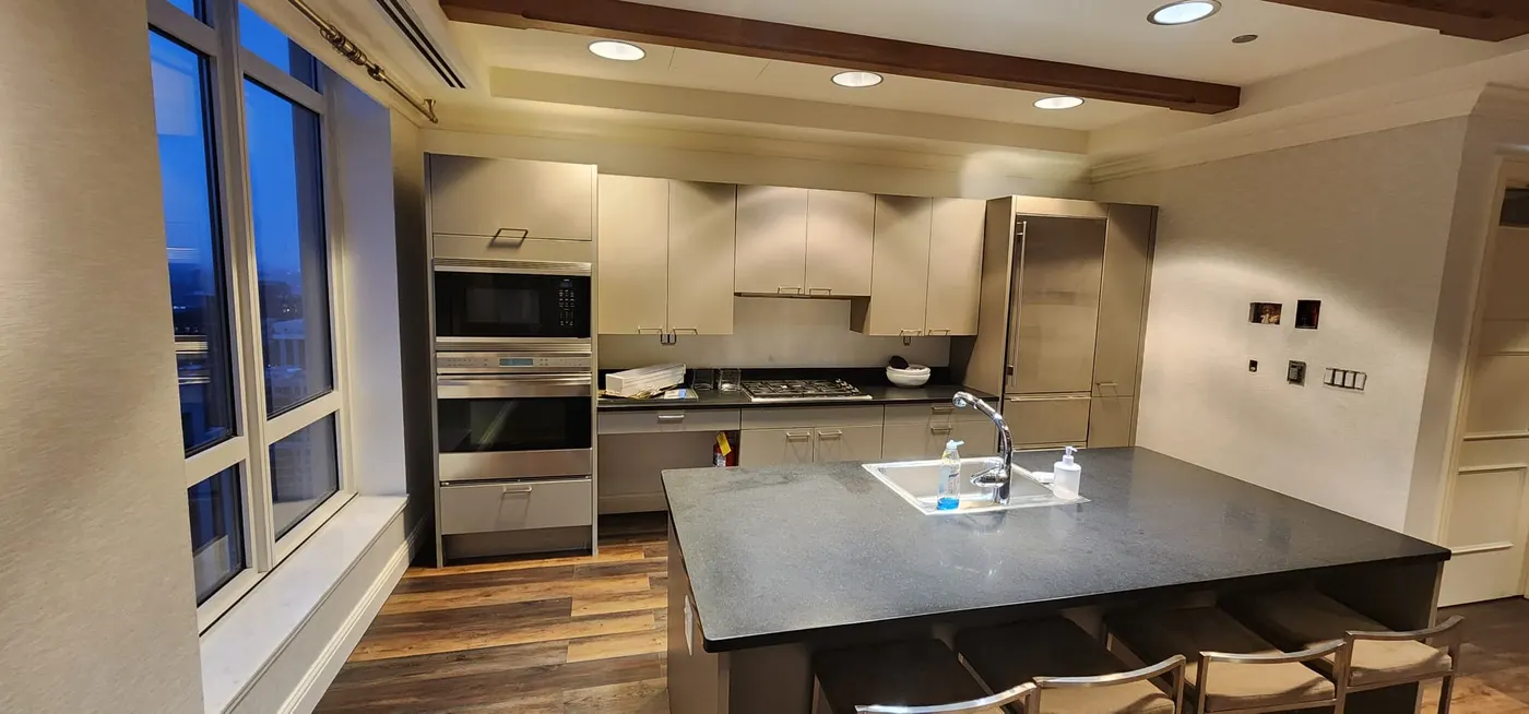 Modern kitchen remodel with built-in oven, gray cabinets, and large dark island in Bloomingdale