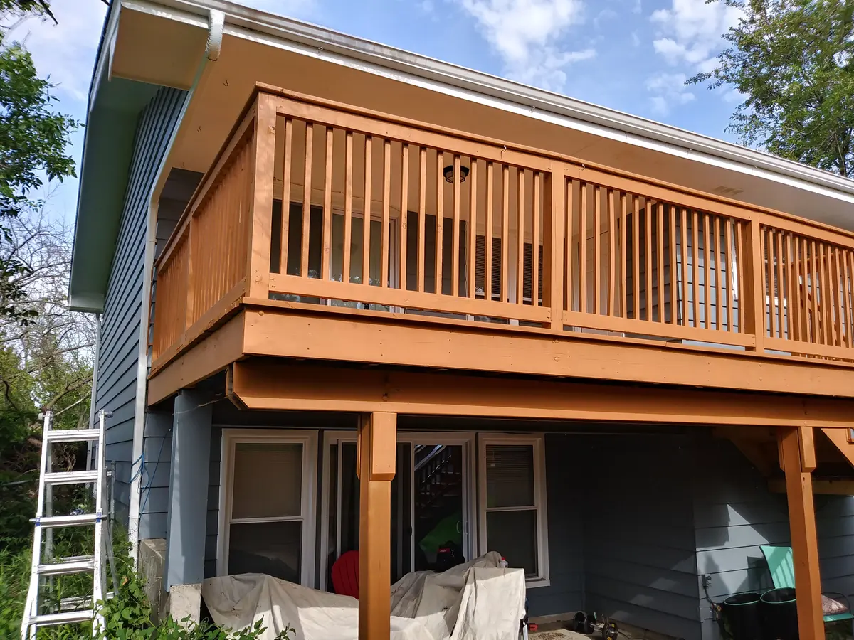 Elevated deck freshly stained on a gray-sided home