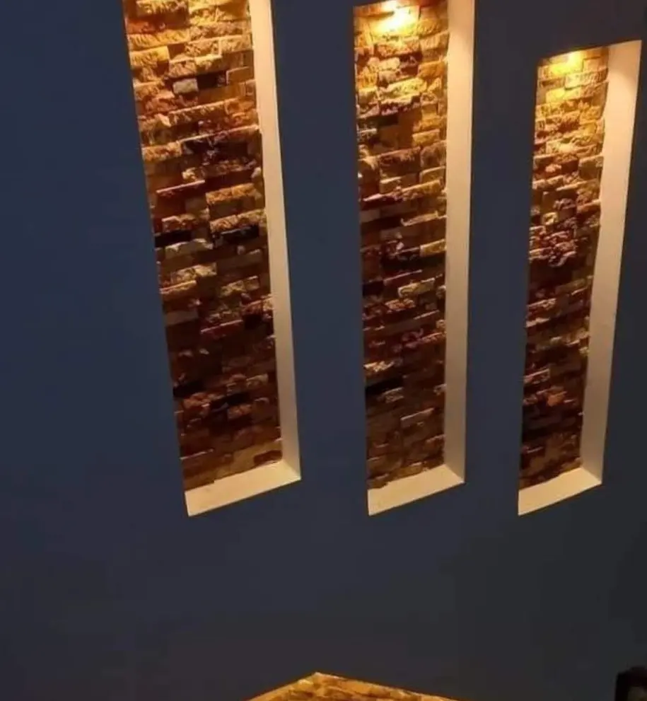 Navy painted wall with recessed stone-tile niches