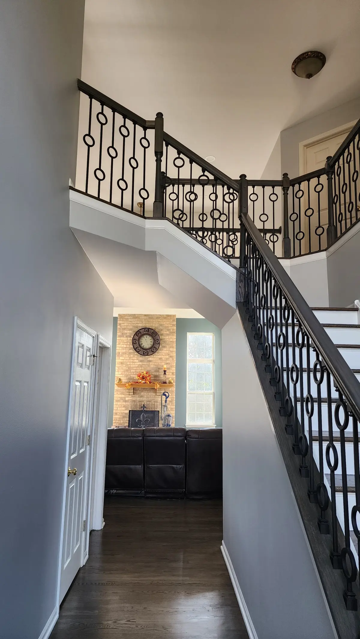 Painted foyer and staircase with gray walls and ornate iron railing